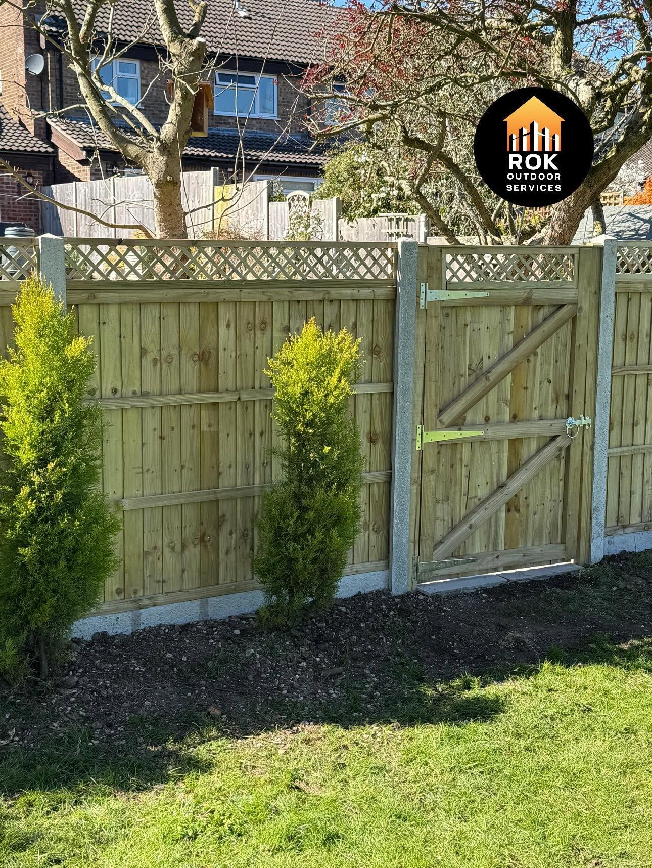 Timber garden gate and fence beside a lawn