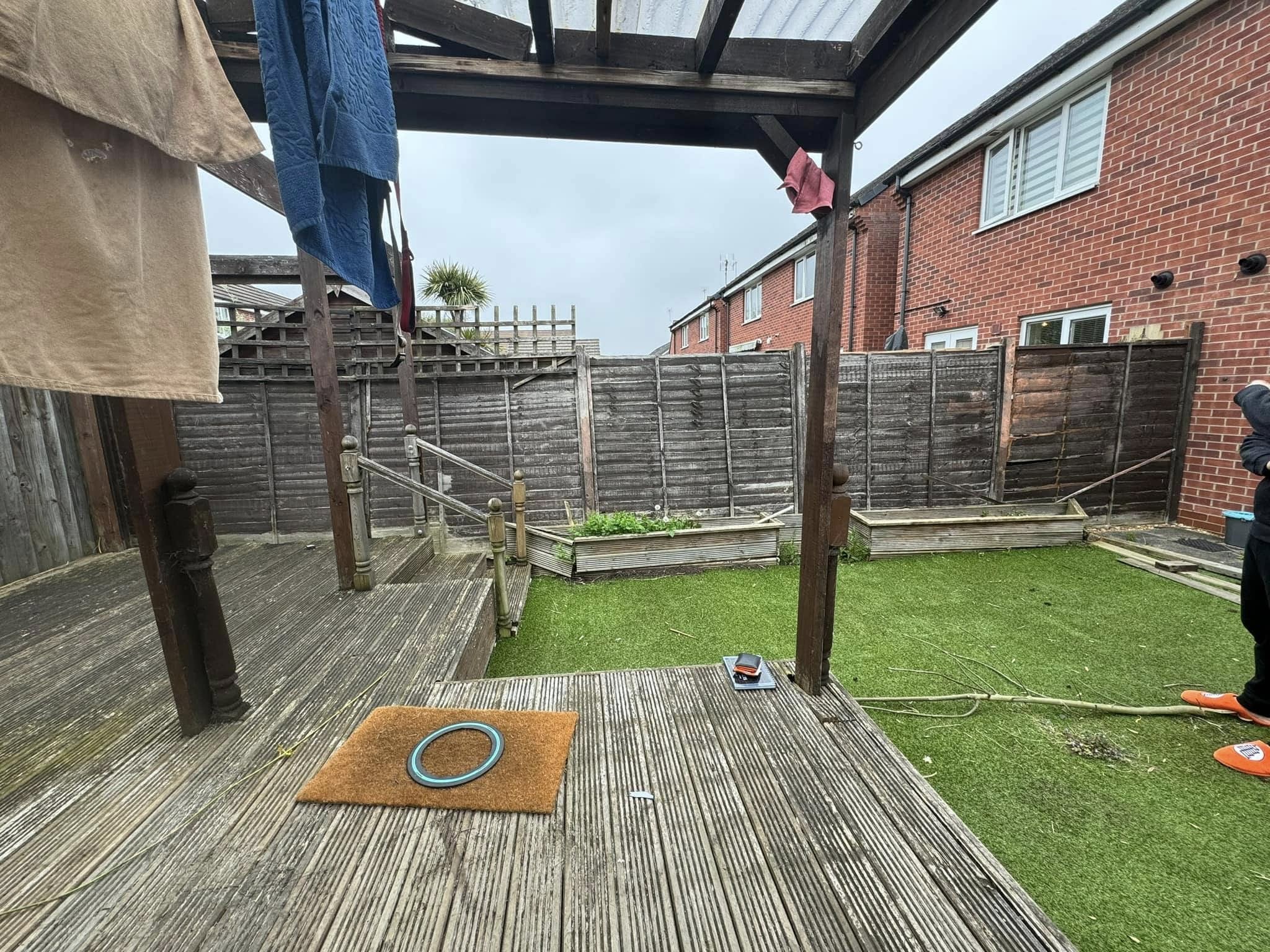 Existing garden fencing before replacement beside a pergola
